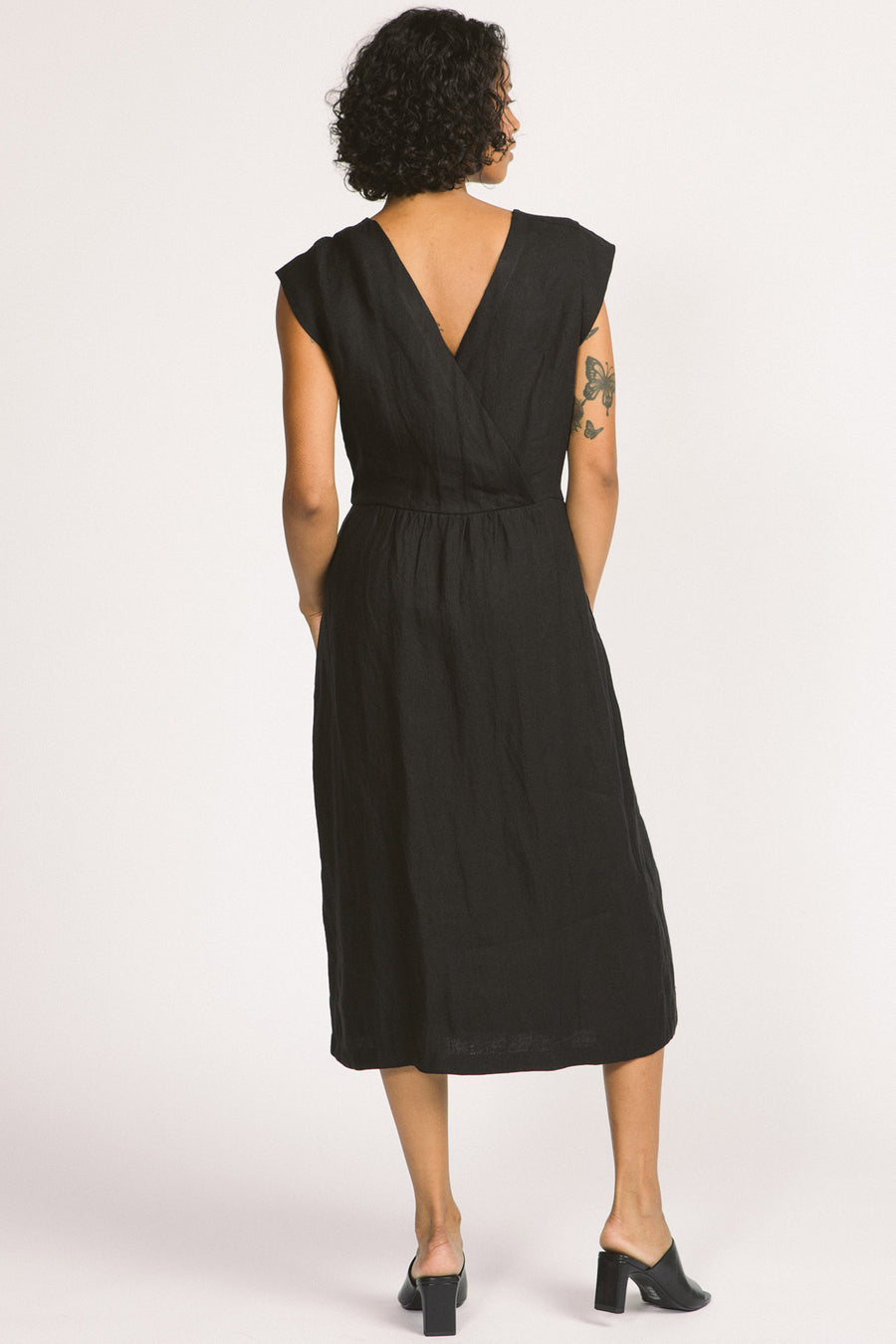 Back view of woman wearing black button up linen midi Blythe dress by Allison Wonderland. 