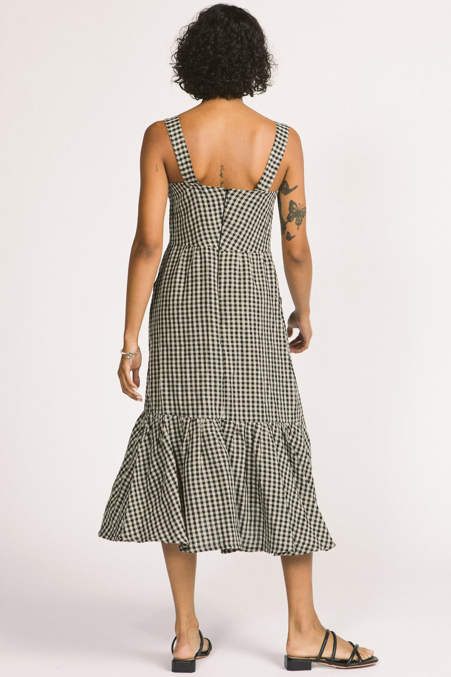 Back view of woman wearing black and white linen gingham tiered Calista summer dress by Allison Wonderland. 