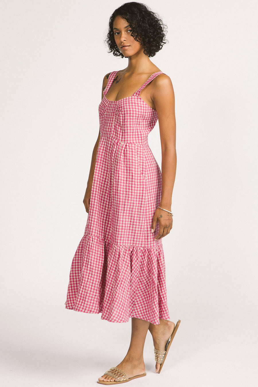 Side view of woman wearing pink and white linen gingham tiered Calista summer dress by Allison Wonderland. 