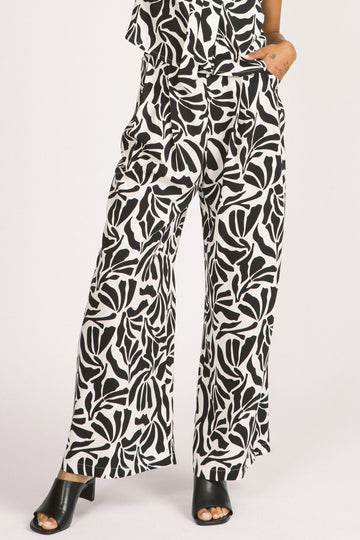 Women wearing black and white zebra leaf print Darcy pants by Allison Wonderland. 