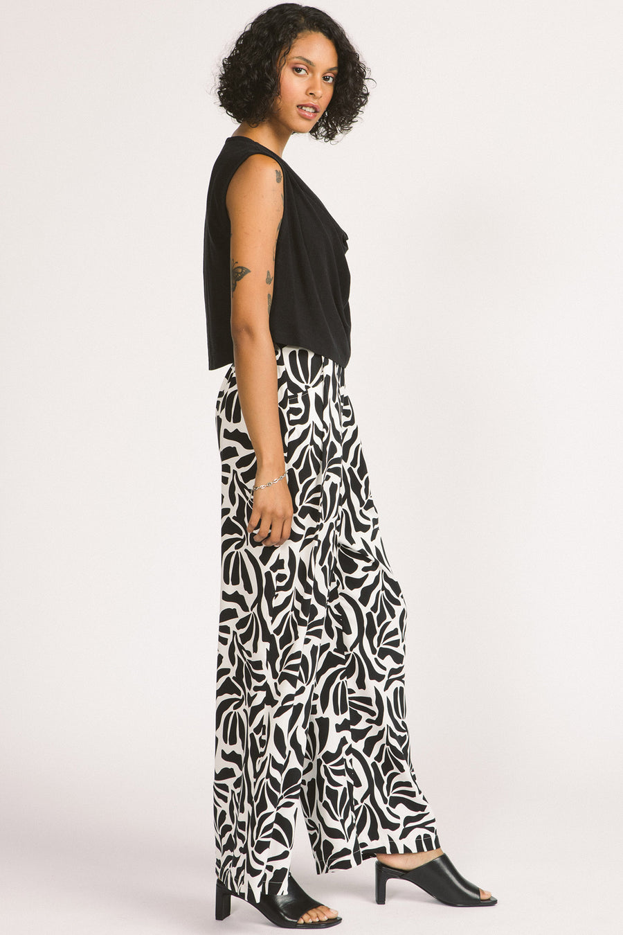 Side view of women wearing black and white zebra leaf print Darcy pants by Allison Wonderland. 