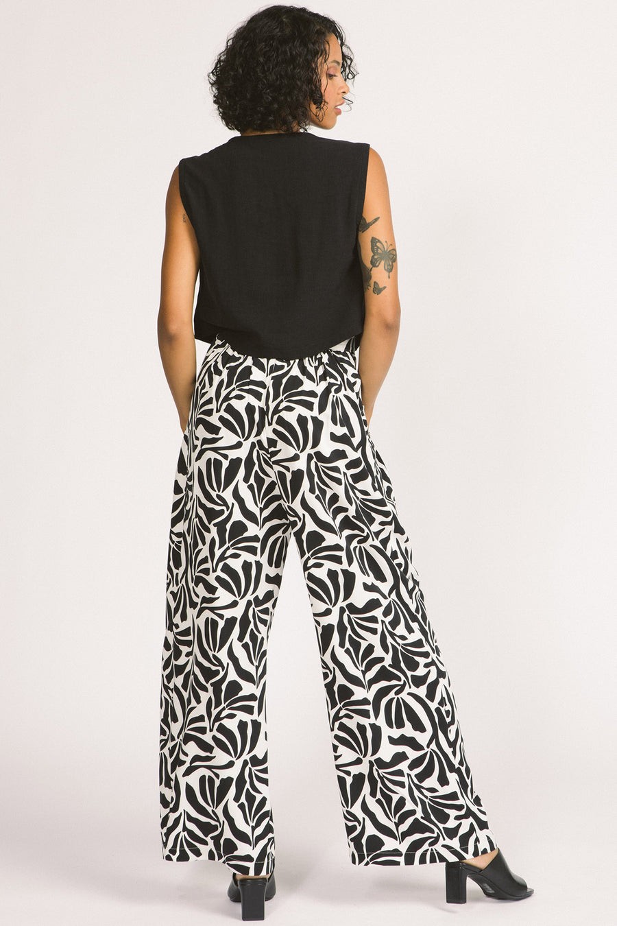 Back view of  women wearing black and white zebra leaf print Darcy pants by Allison Wonderland. 