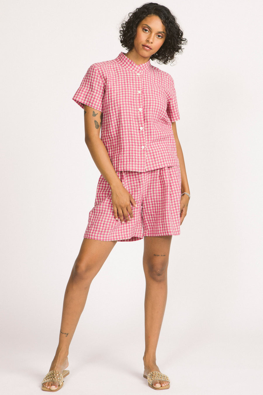 Woman wearing a pink and white linen gingham button up Elodie blouse by Allison Wonderland. 