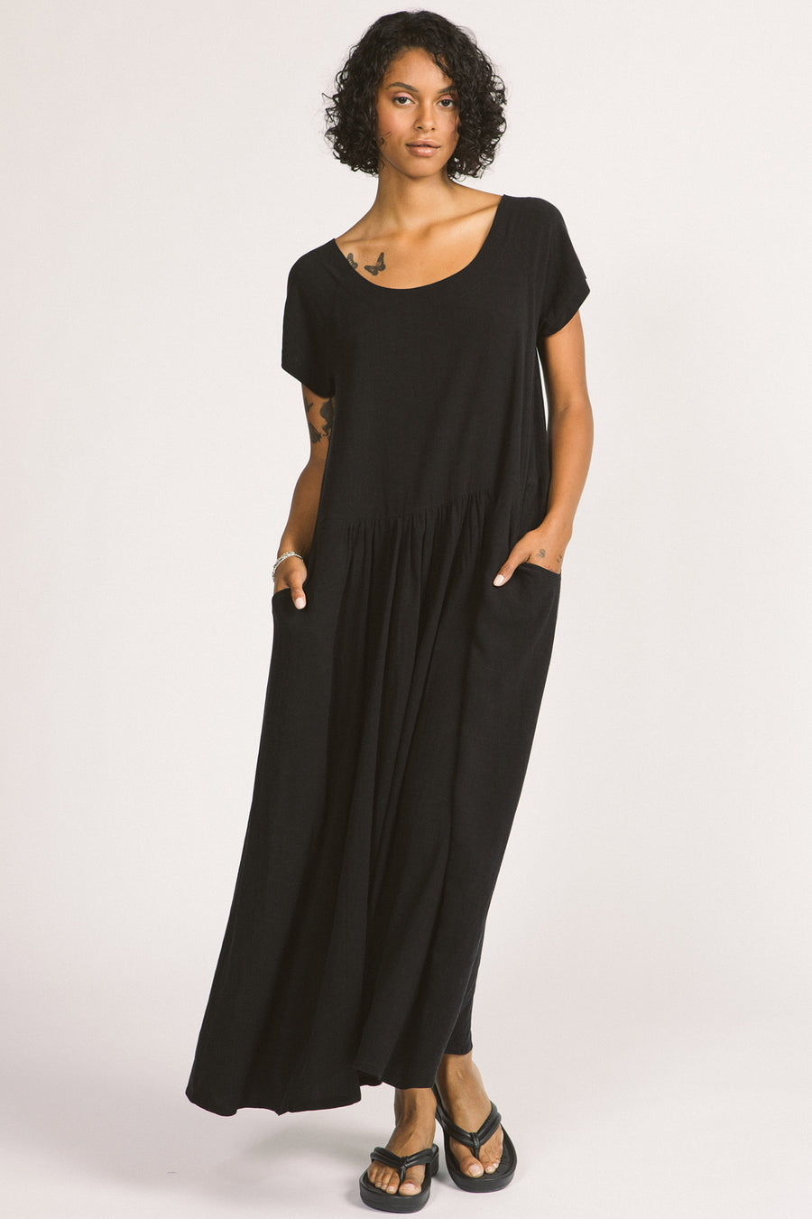 Woman wearing black maxi Allison Wonderland Enola Dress. 