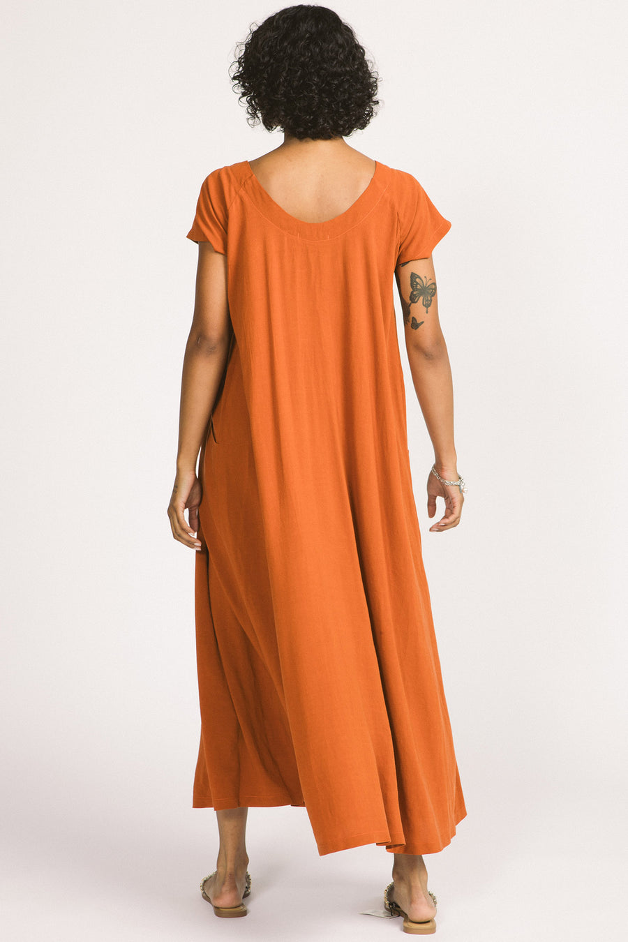 Back view of woman wearing cognac maxi Allison Wonderland Enola Dress. 