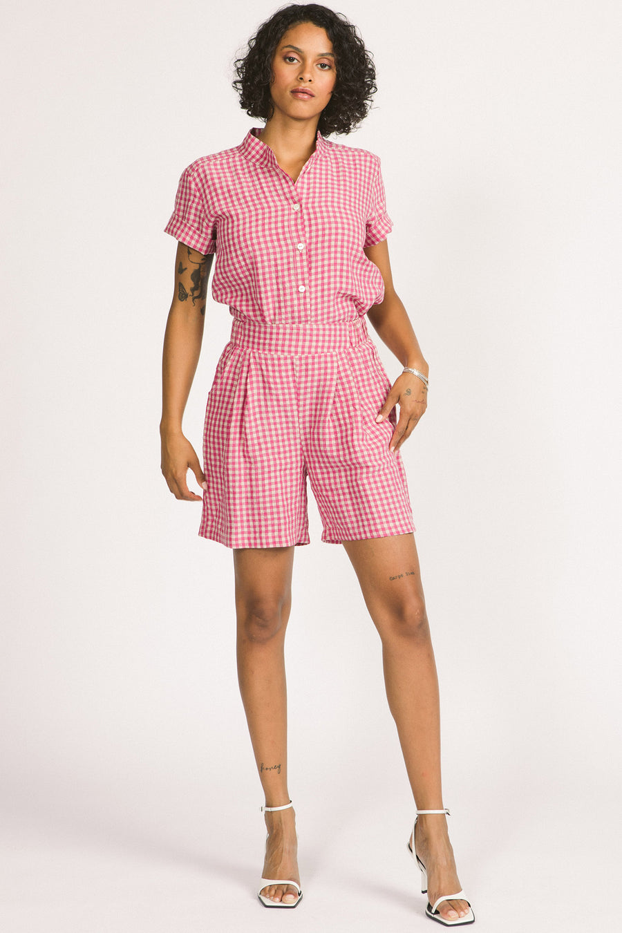 Woman wearing pink and white gingham Kim shorts by Allison Wonderland. 