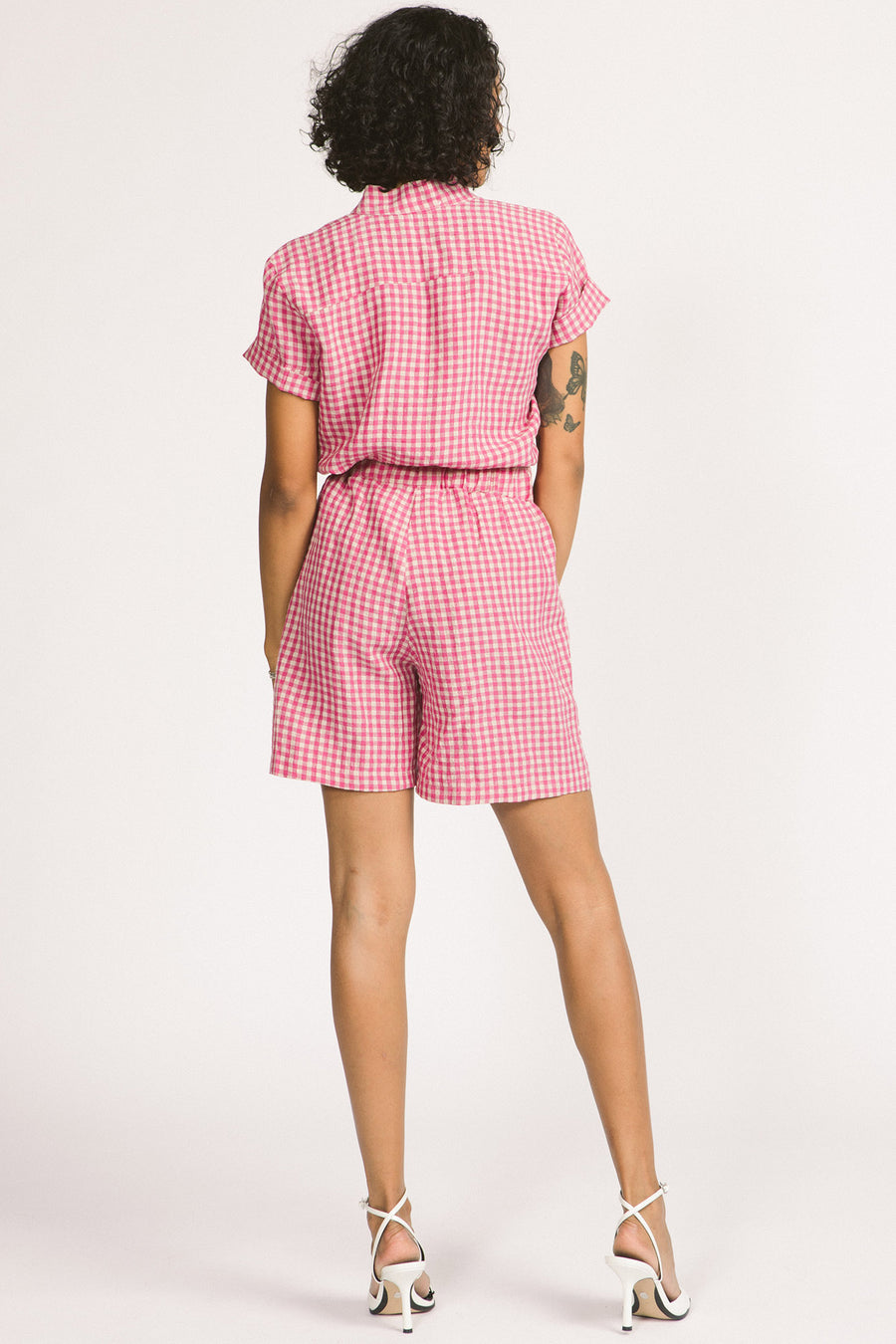 Back view of woman wearing pink and white gingham Kim shorts by Allison Wonderland. 
