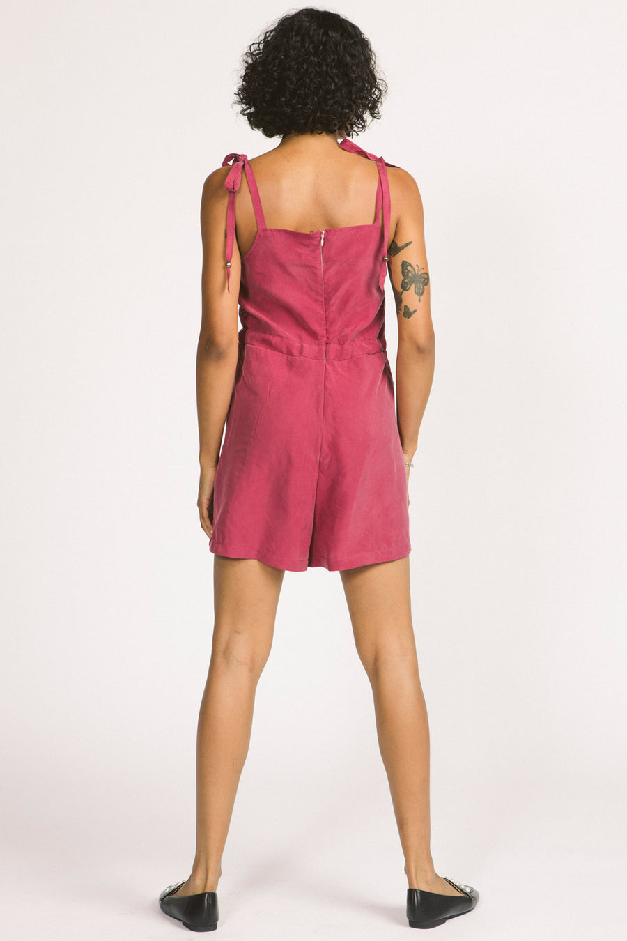 Back view of woman wearing magenta pink short Meara short romper by Allison Wonderland. 