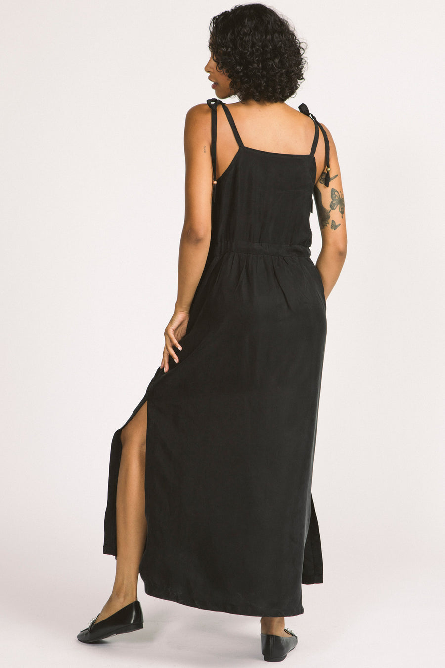 Back view of woman wearing black Novalie dress by Allison Wonderland with adjustable shoulder straps and waist. 