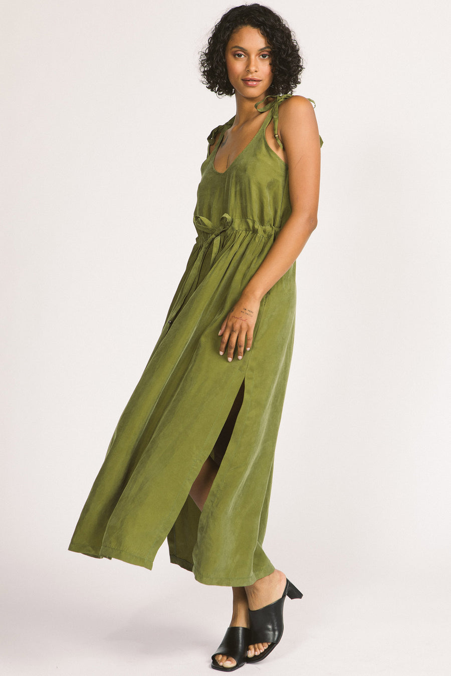 Woman wearing moss green Novalie dress by Allison Wonderland with adjustable shoulder straps and waist. 