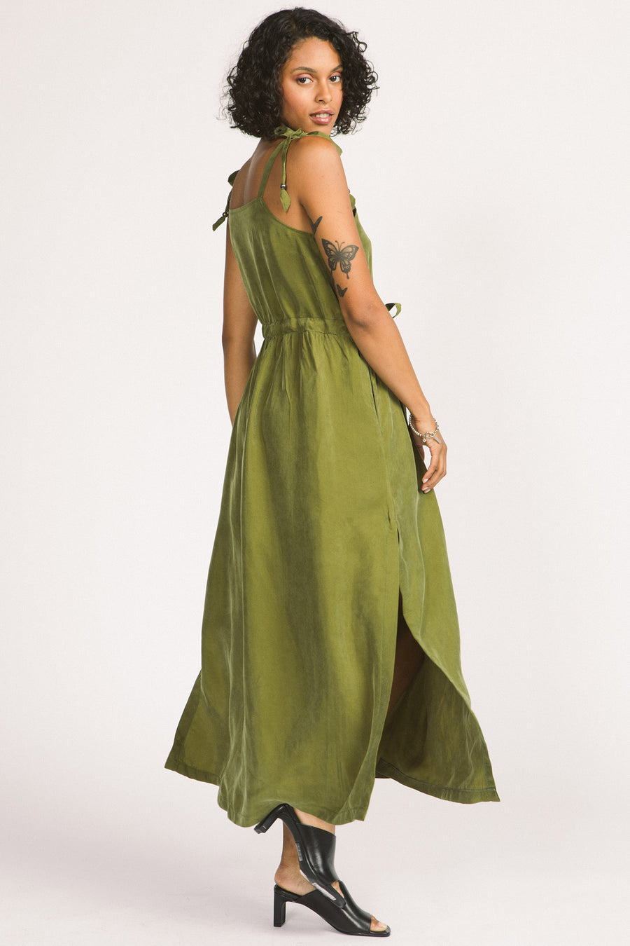Back view of woman wearing moss green Novalie dress by Allison Wonderland with adjustable shoulder straps and waist. 