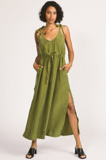 Woman wearing moss green Novalie dress by Allison Wonderland with adjustable shoulder straps and waist. 