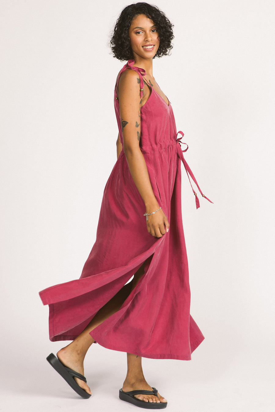 Side view of woman wearing magenta pink Novalie dress by Allison Wonderland with adjustable shoulder straps and waist. 