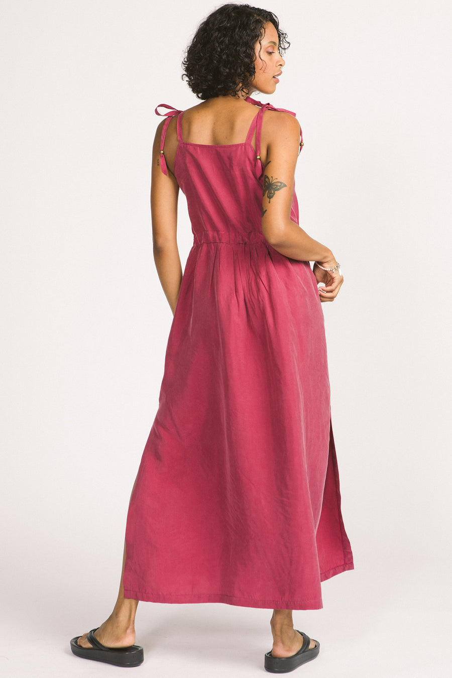 Back view of woman wearing magenta pink Novalie dress by Allison Wonderland with adjustable shoulder straps and waist. 