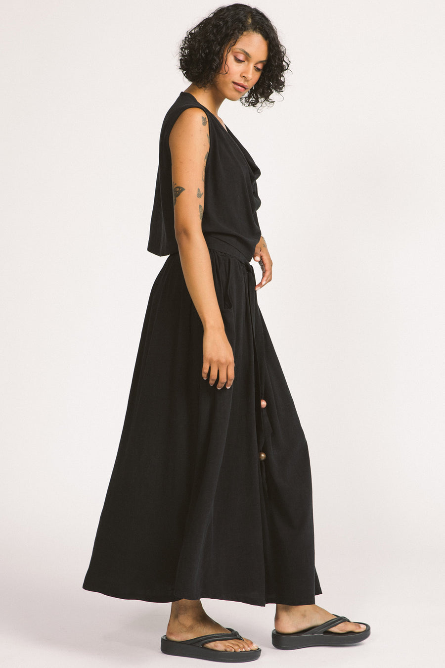 Side view of woman wearing black Oriana maxi skirt by Allison Wonderland. 