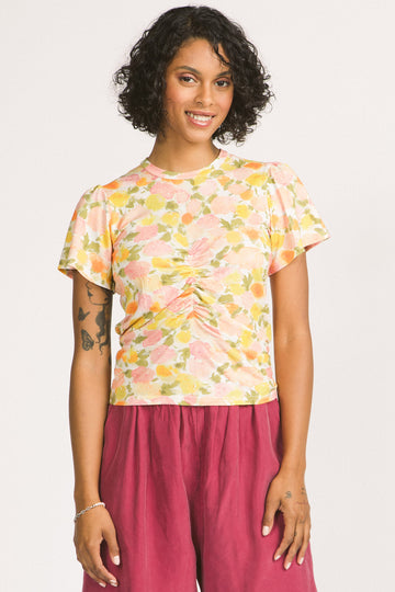 Woman wearing yellow floral print Solana top by Allison Wonderland. 