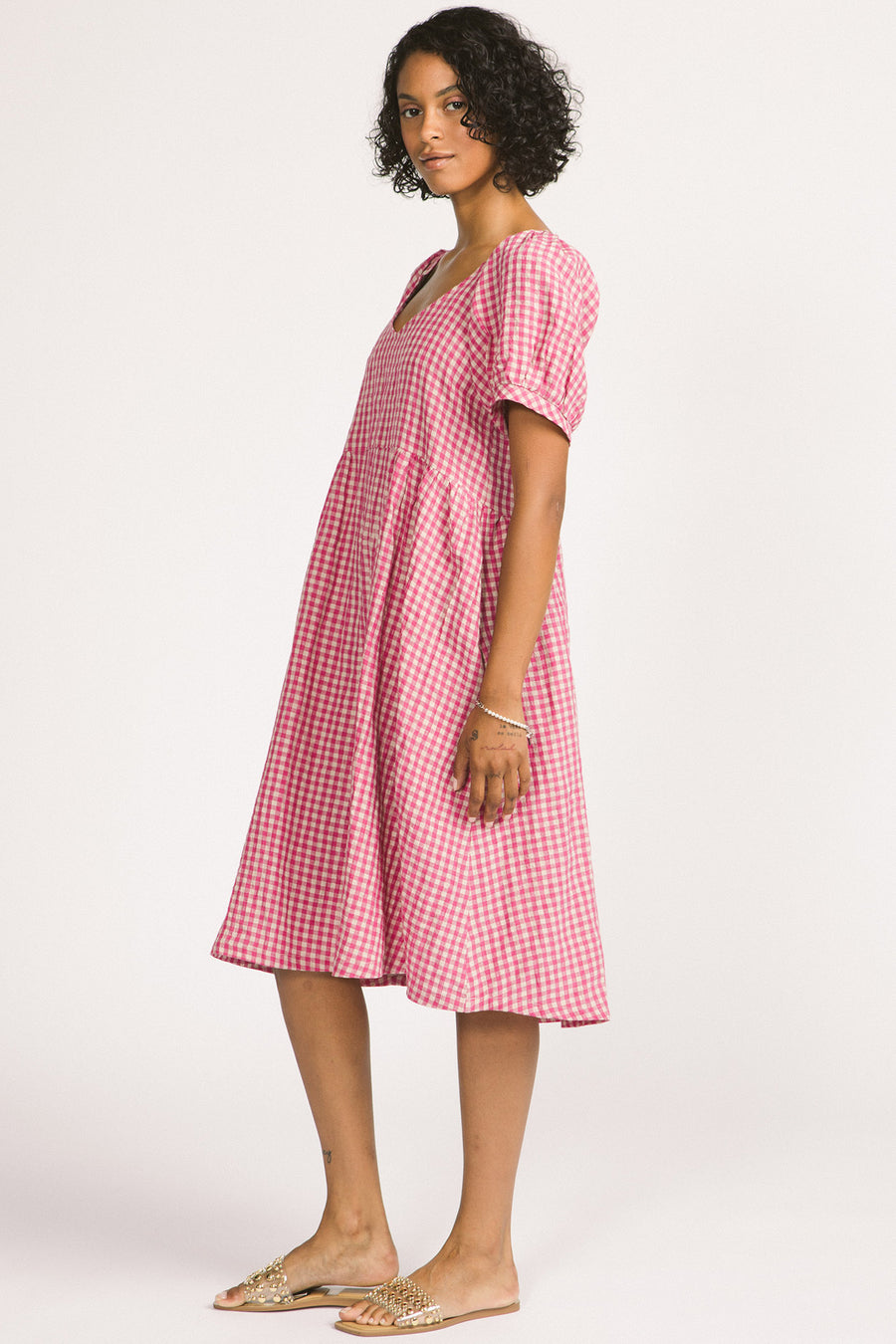 Side view of woman wearing pink and white linen gingham oversized babydoll Verity dress. 