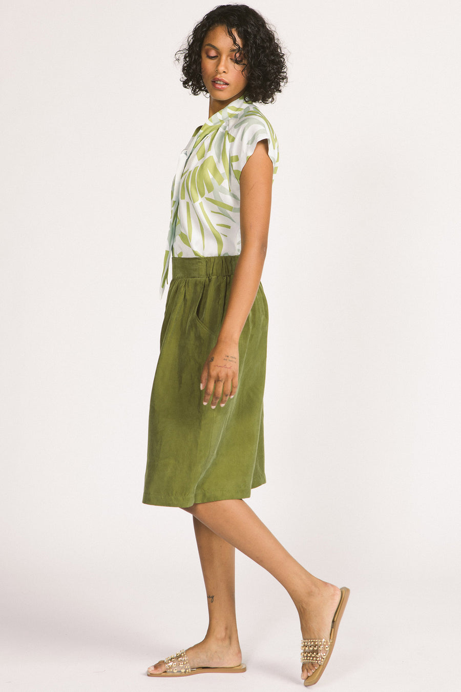 Side view of woman wearing moss green culotte Yara shorts by Allison Wonderland. 