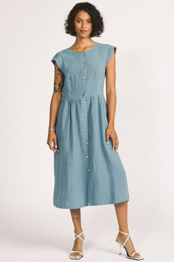 Back view of woman wearing sky blue button up linen midi Blythe dress by Allison Wonderland. 