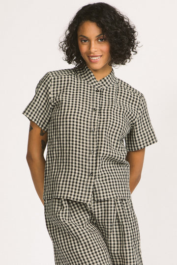 Woman wearing a black and white linen gingham button up Elodie blouse by Allison Wonderland. 