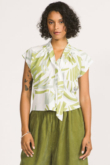 Woman wearing a green and white leaf print Isabeau blouse by Allison Wonderland. 