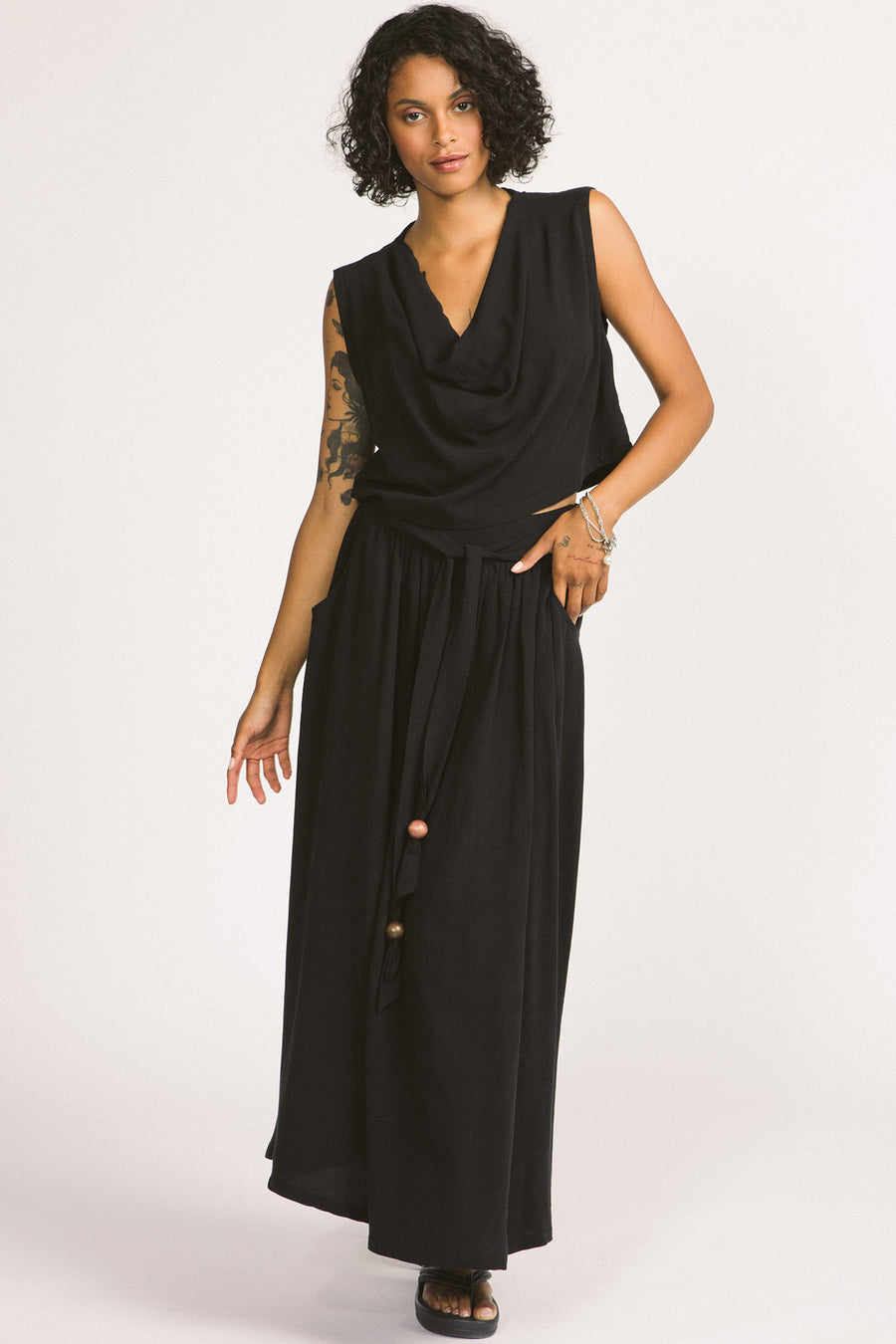 Woman wearing black cowl neck sleeveless Kiko blouse by Allison Wonderland. 