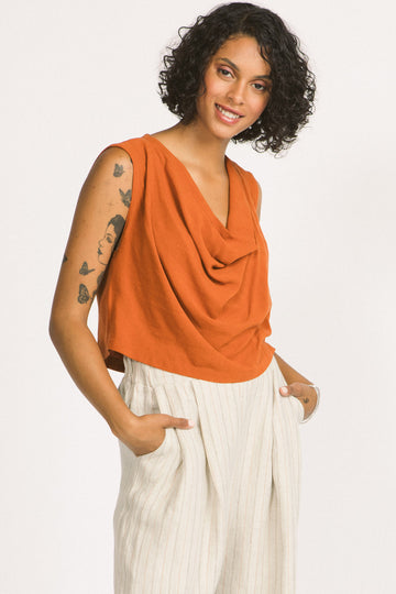 Woman wearing cognac orange cowl neck sleeveless Kiko blouse by Allison Wonderland. 