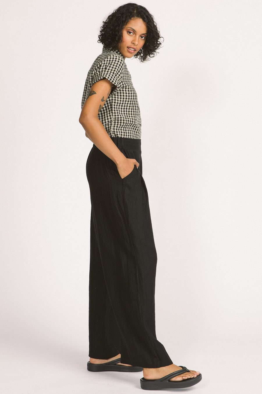 Side view of woman wearing black linen wide leg Romy pants by Allison Wonderland. 