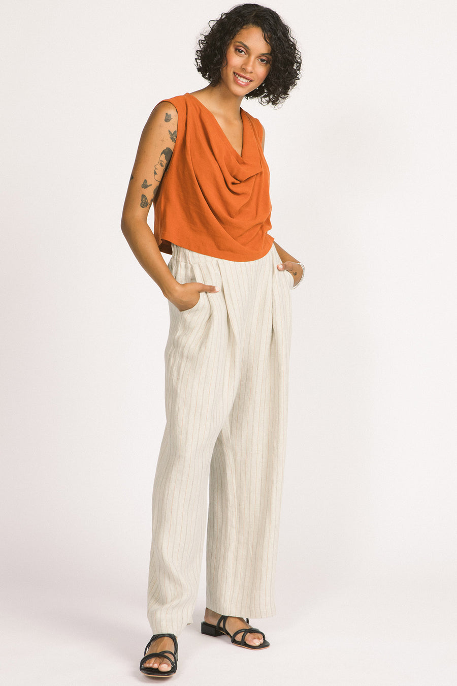 Side view of woman wearing ivory stripe linen wide leg Romy pants by Allison Wonderland. 