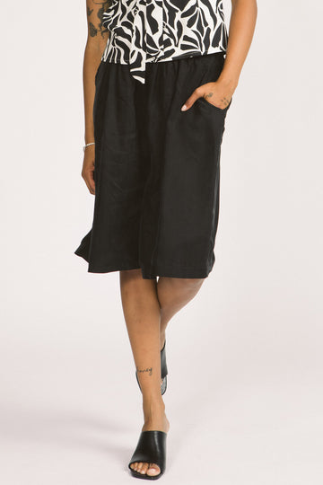 Close-up of woman wearing black culotte Yara shorts by Allison Wonderland. 