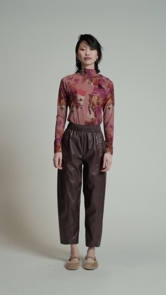 Video of a model in a studio wearing a pink print Aches top.