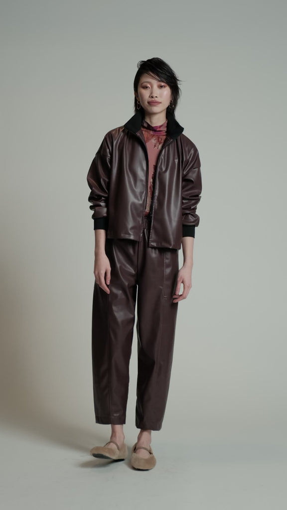 Video of a model in a studio wearing burgundy HRT pants.