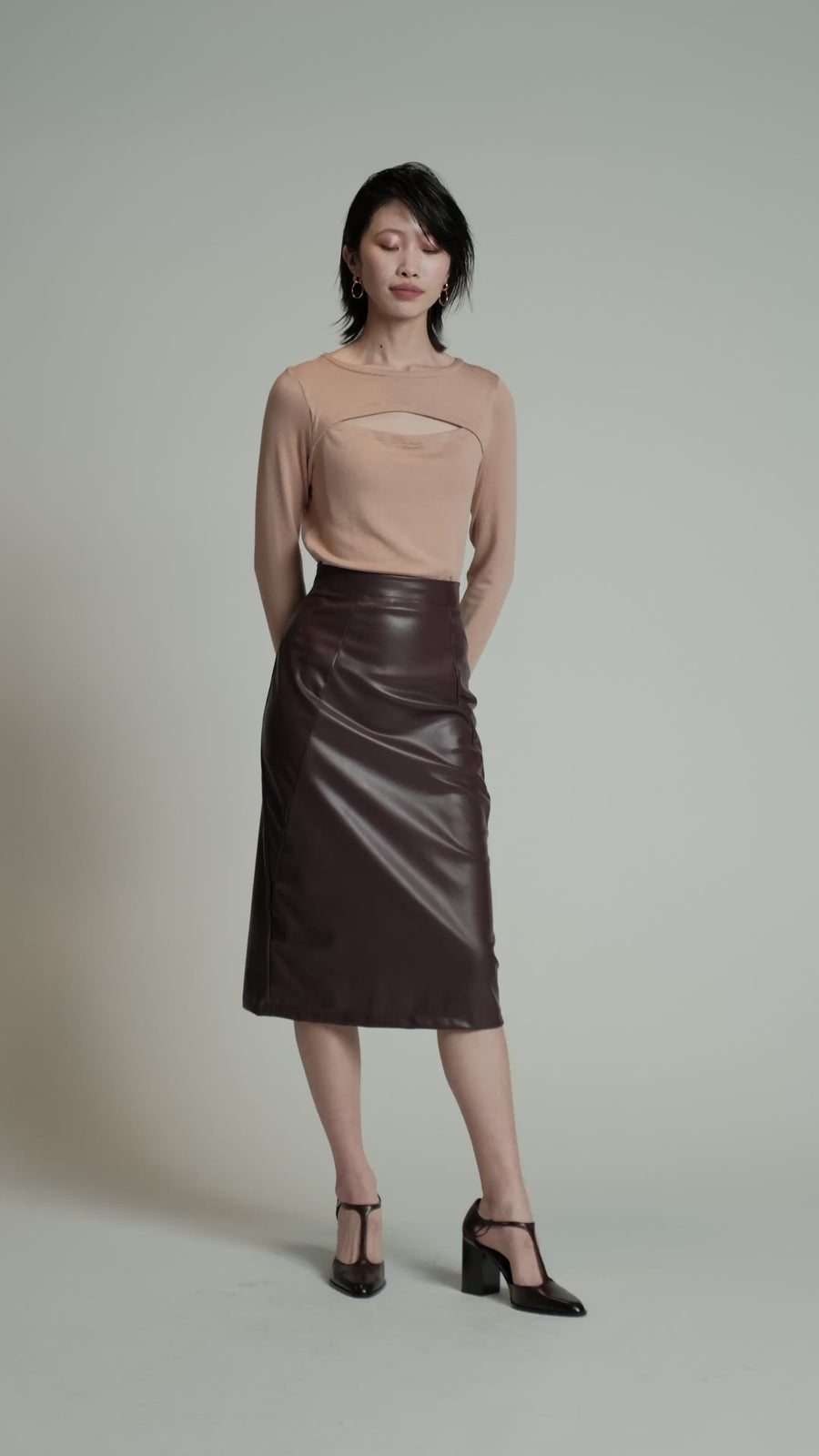 A video of a model in a studio wearing a burgundy Desire skirt.